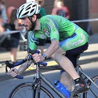 photo of male cyclist riding bicycle in a road race